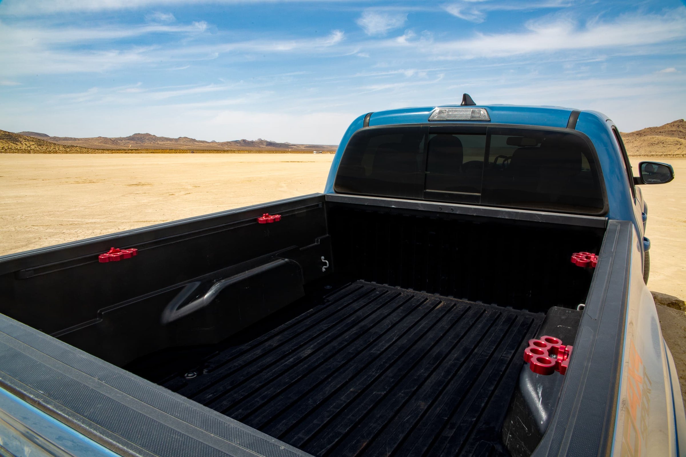 Red Truck Knucks billet aluminum truck bed accessory in a Toyota Tacoma in the desert