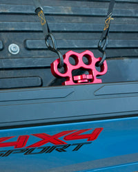 Red Truck Knucks with 2 ratchect straps hooked in bed of Toyota Tacoma